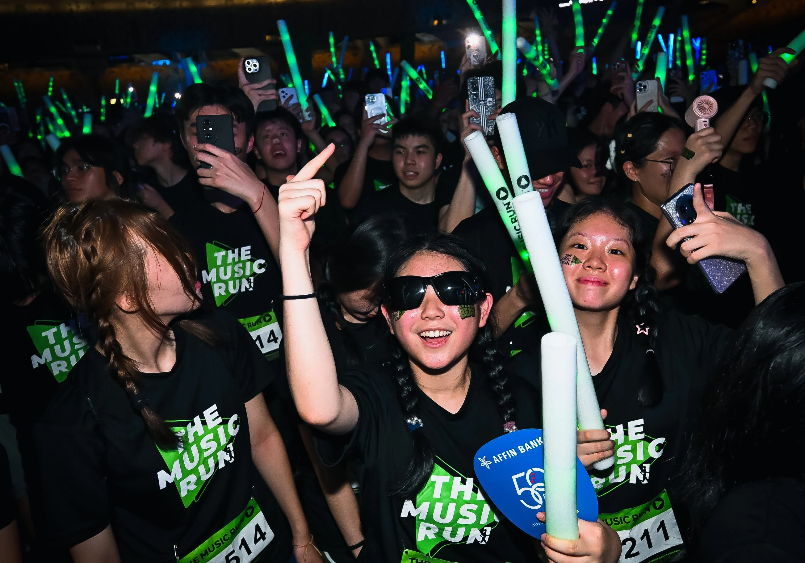 Music Run Manila participants celebrating at night with glowing light sticks